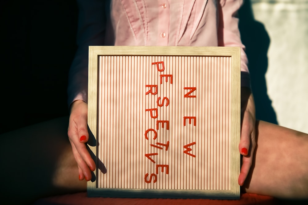 a person holding a sign that says never sustenance