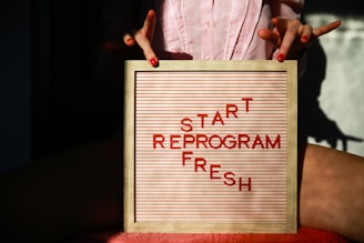 a person holding a sign that says start reprogram fresh