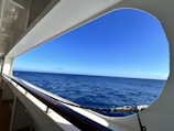 A panoramic view from the ship’s bow showing endless blue waves and a clear sky.