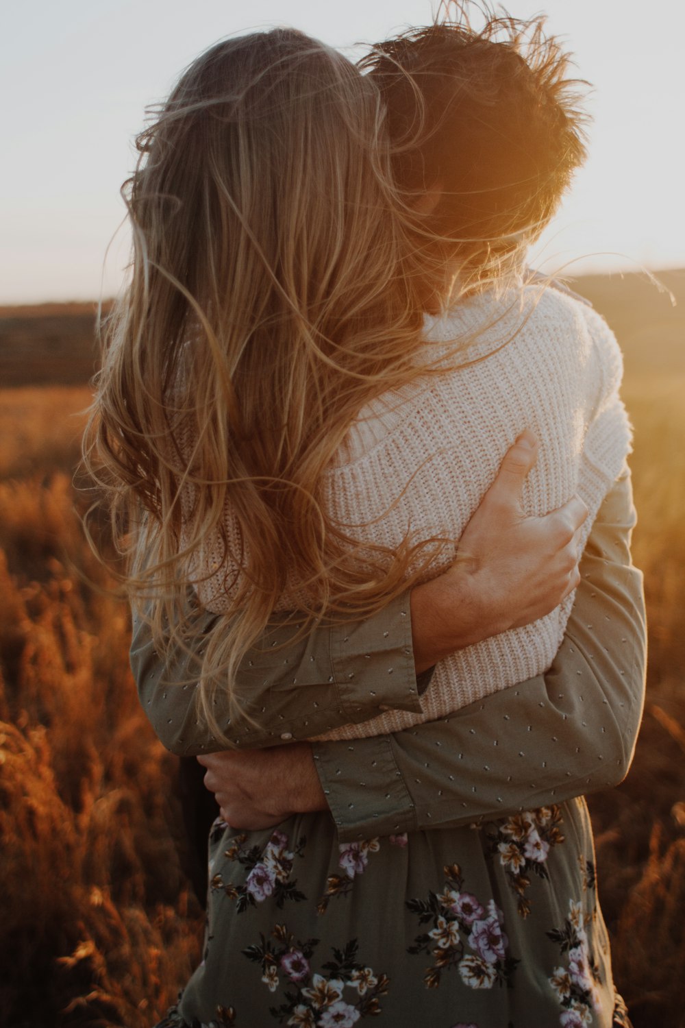 a couple embracing each other in a field
