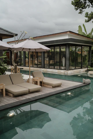 a pool with lounge chairs and umbrellas next to it