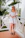 Smiling woman enjoying a sunny morning on a hotel balcony surrounded by tropical plants