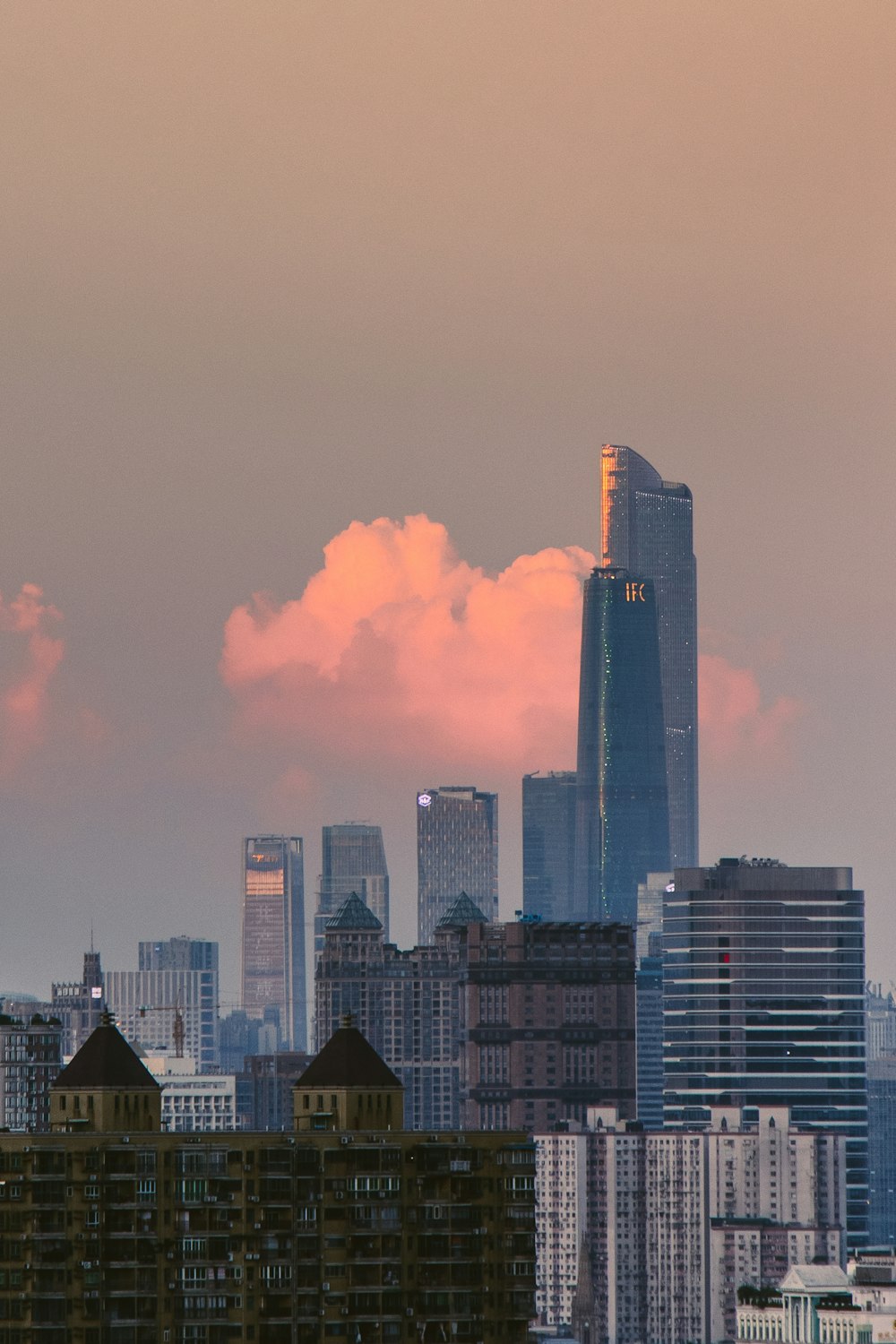a view of a city skyline with a pink cloud in the sky
