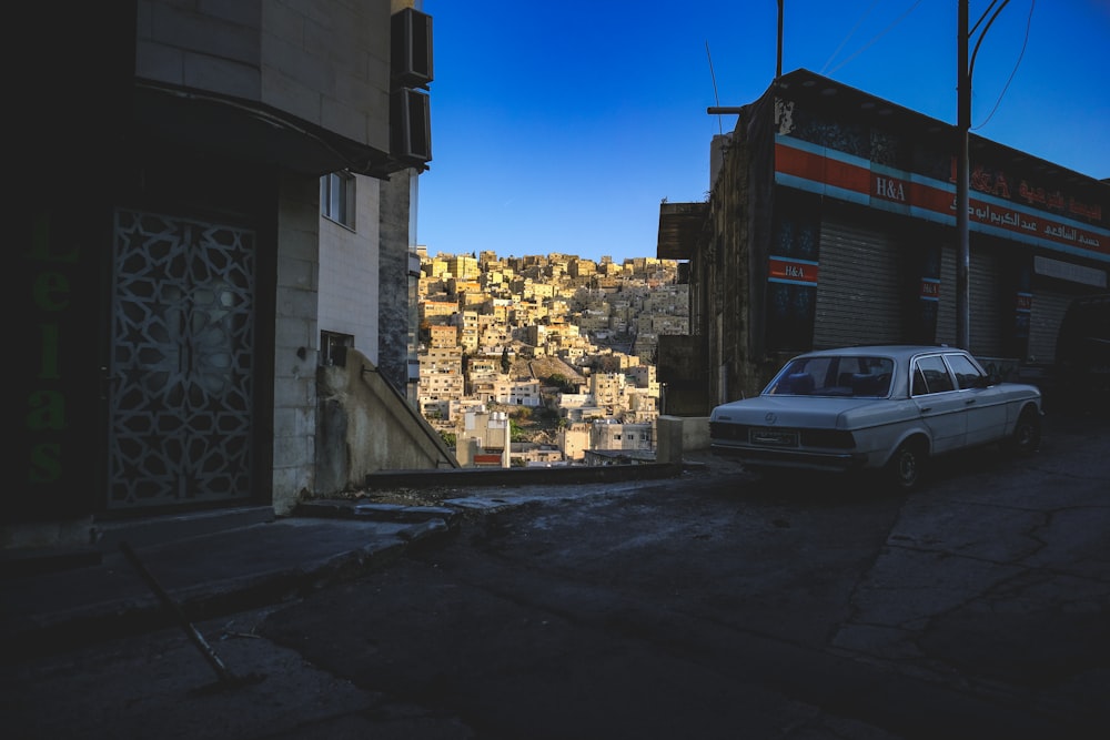 a car parked on the side of a road next to a building