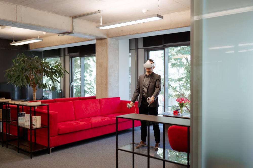 a man standing in a room with a red couch