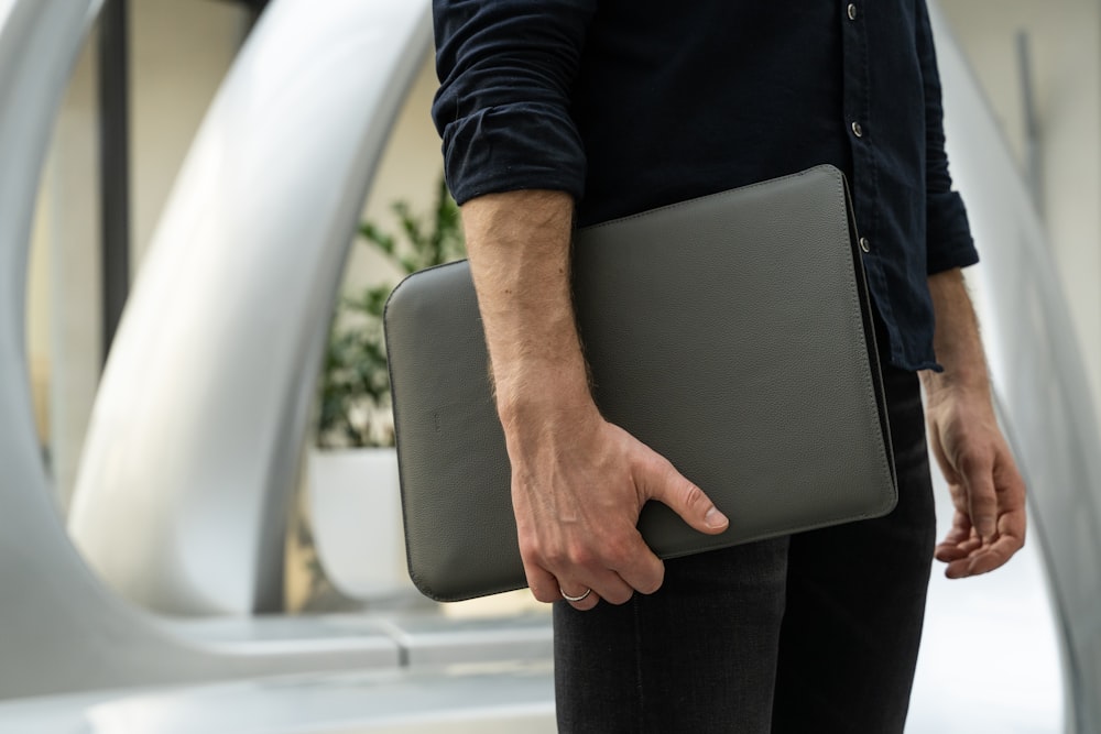 a man holding a laptop in his hand