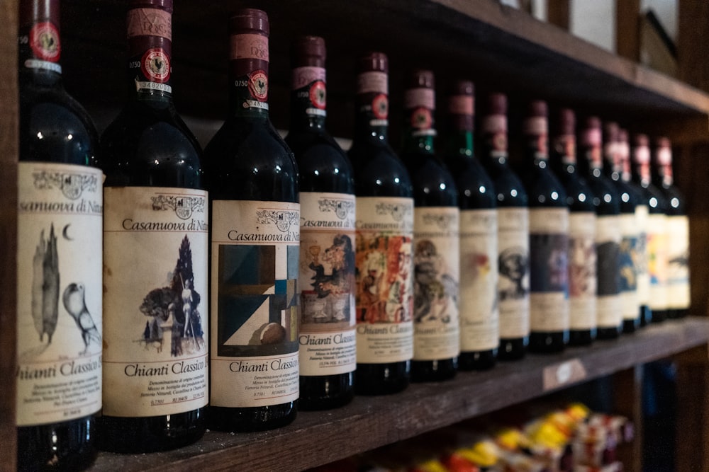 a row of bottles of wine on a wooden shelf