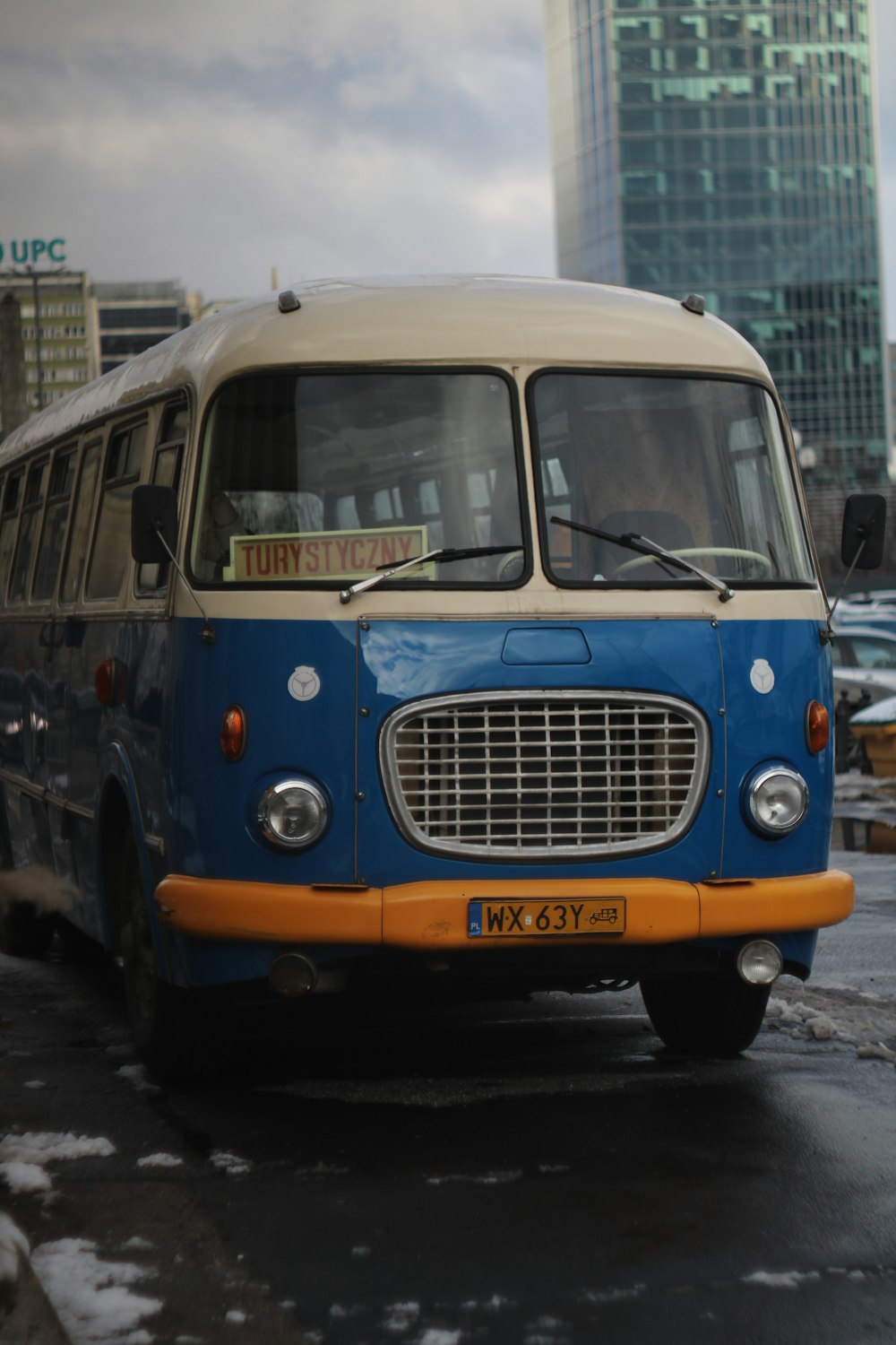 a blue and white bus driving down a street