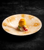 Close-up of a beautifully plated dessert with gold leaf garnish and modern styling.