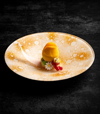 Close-up of a beautifully plated dessert with gold leaf garnish and modern styling.