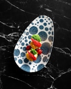 Close-up of a child-safe divided plate with colorful food sections on a bright background.