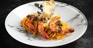 a white plate topped with pasta and shrimp