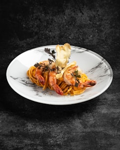 A beautifully plated gourmet pasta dish with soft lighting.
