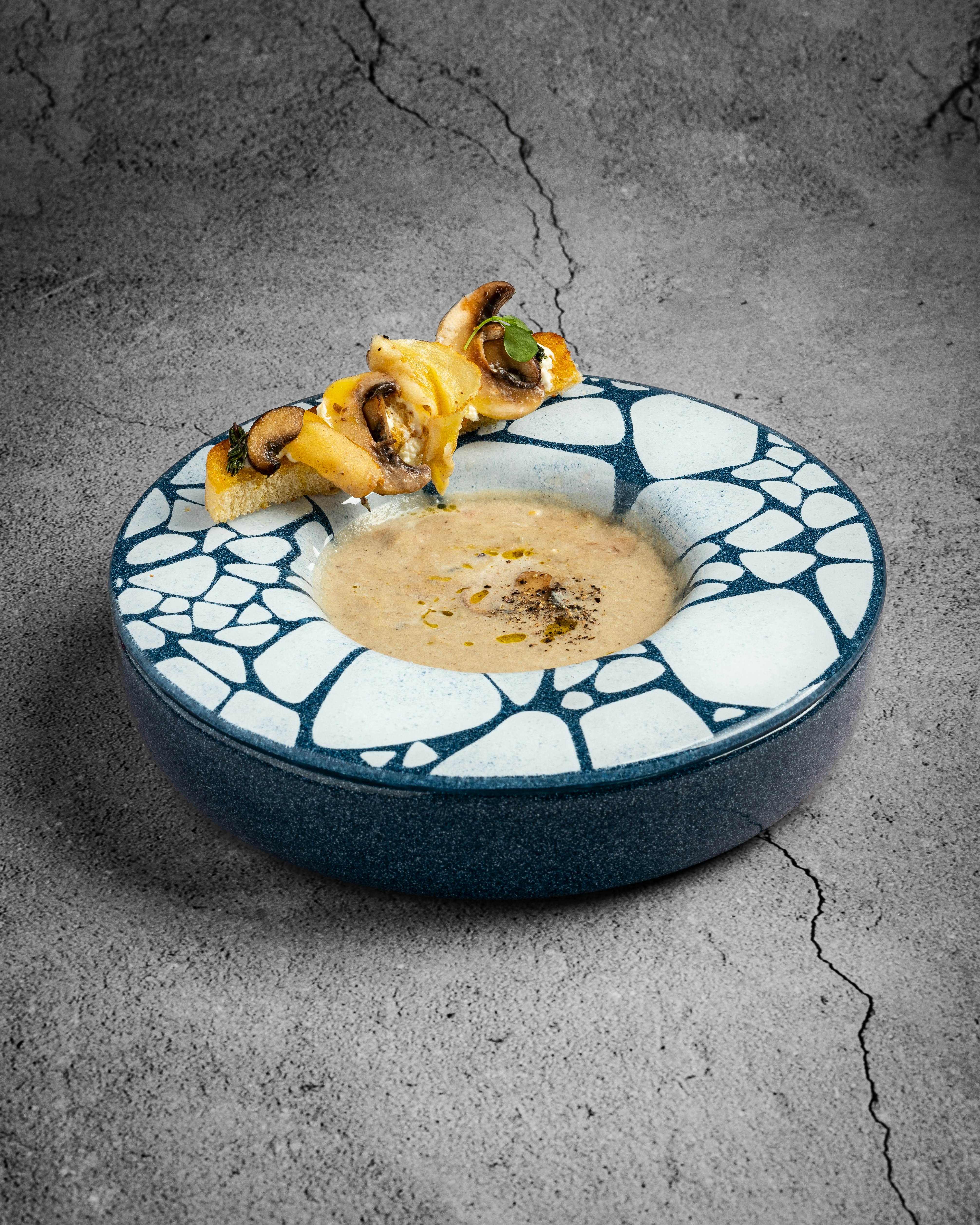 eine Schüssel Suppe mit einem Stück Pizza drauf