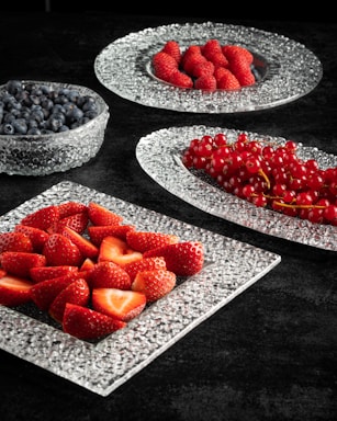 a table topped with plates of fruit and berries
