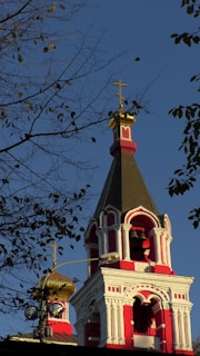 a red and white church steeple with a cross on top