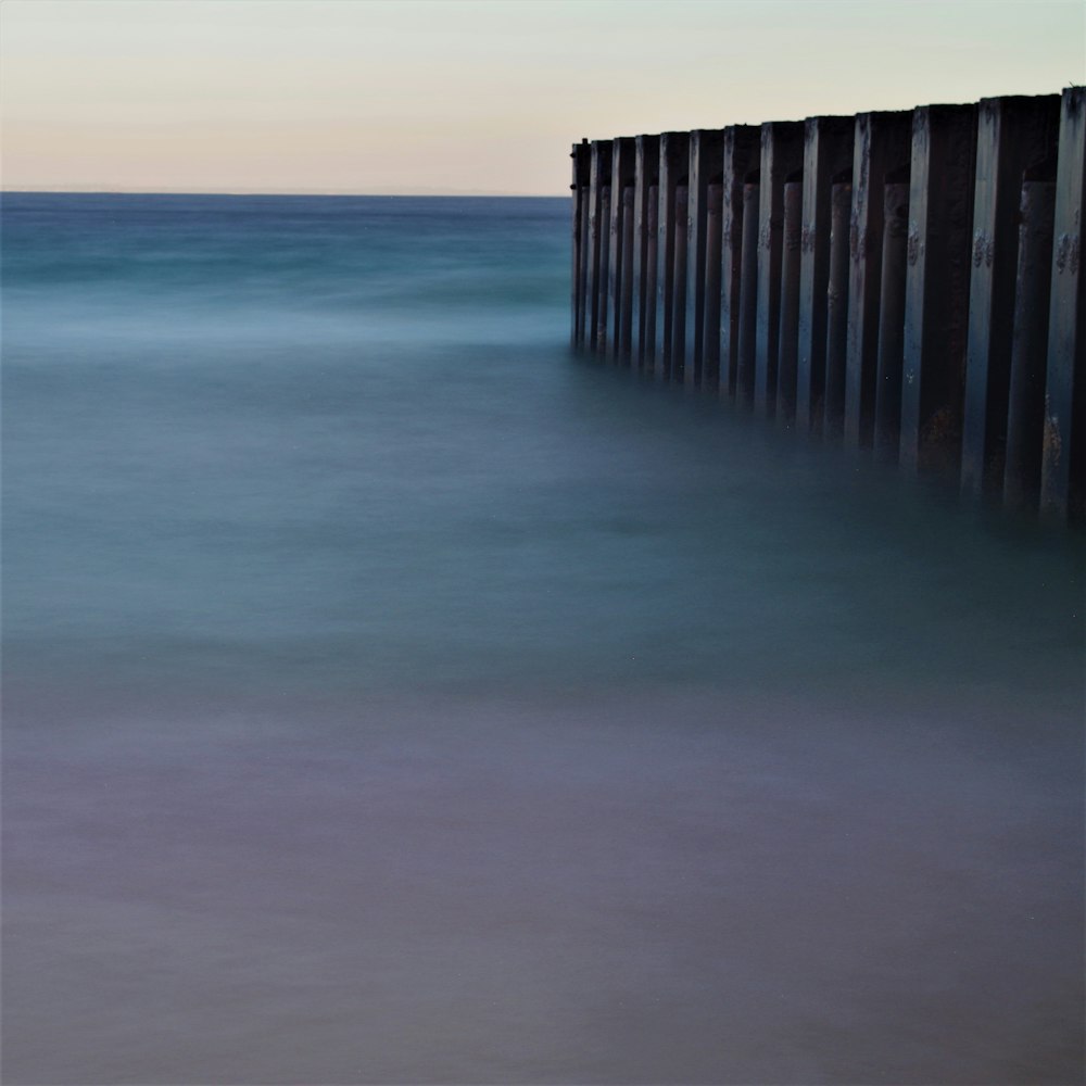 a long exposure photo of the ocean and a pier