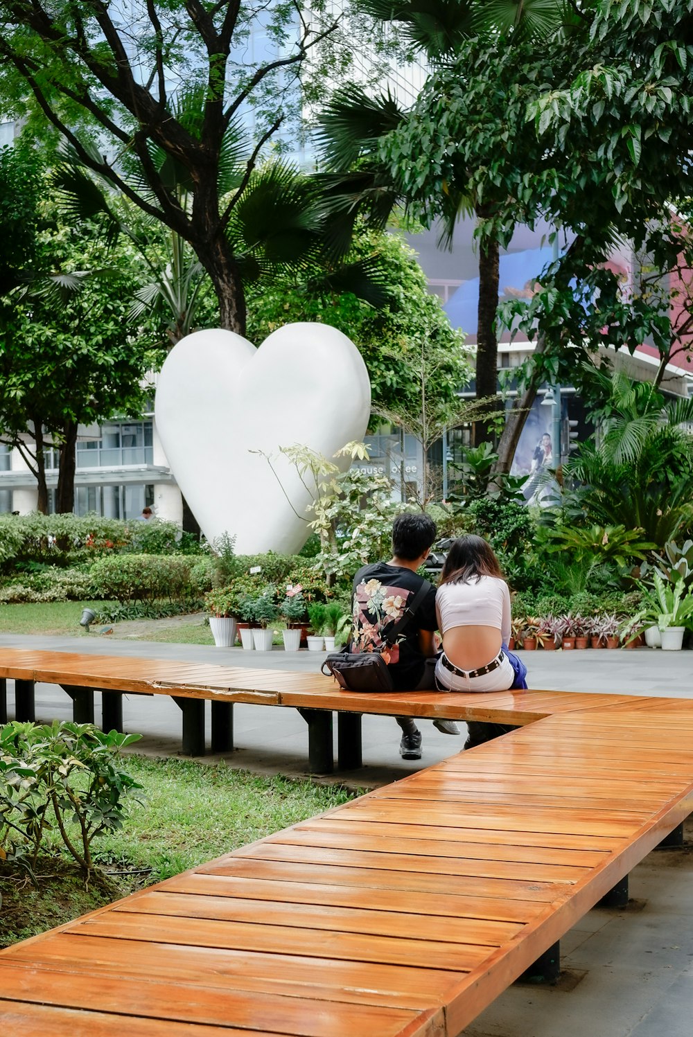 two people sitting on a bench in a park