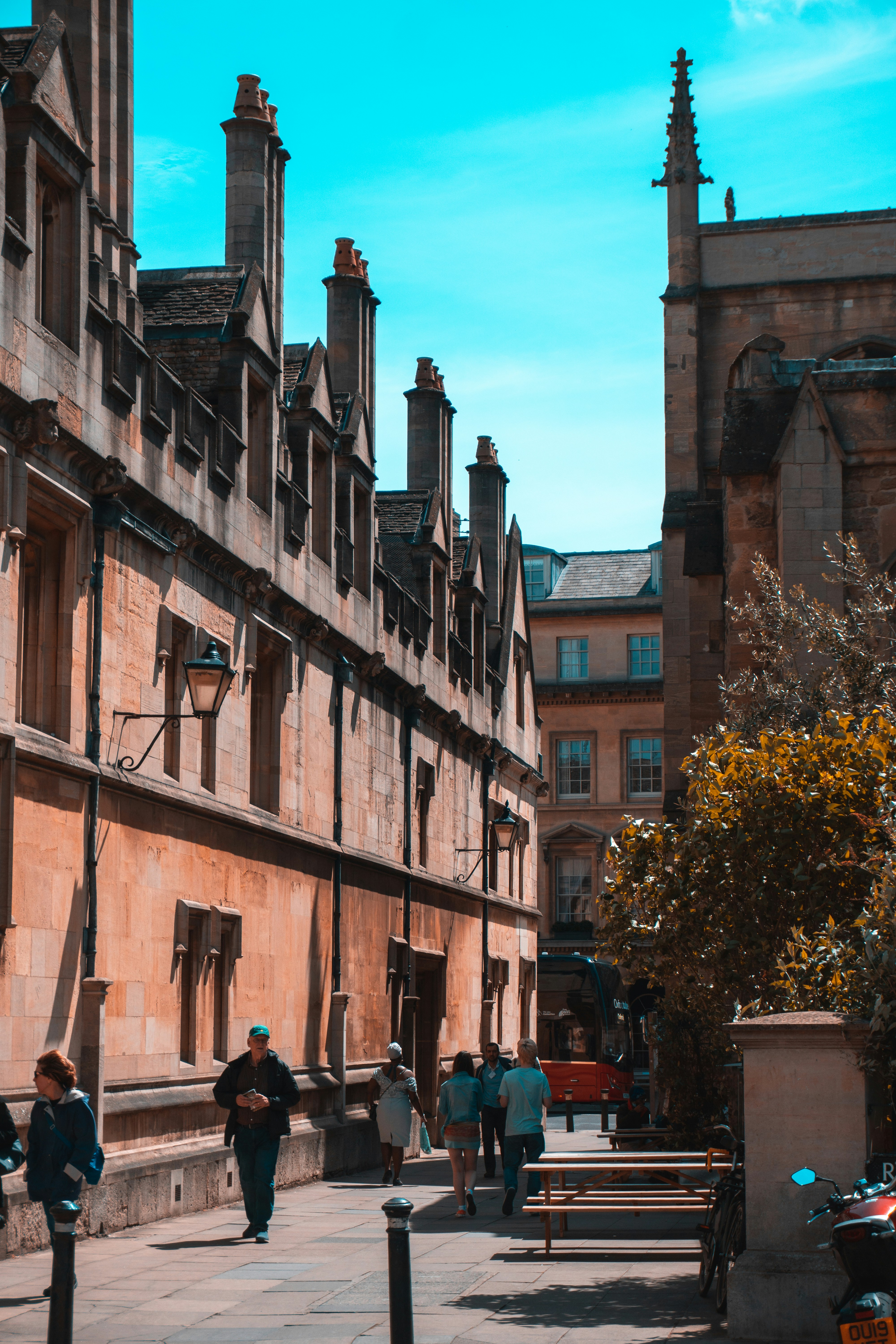 a group of people walking down a street next to tall buildings