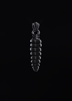 A silver pendant shaped like a small sun reflecting bright light against a deep blue background