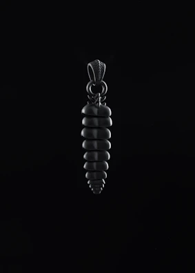 An elegant pendant catching the light against a dark, textured background.