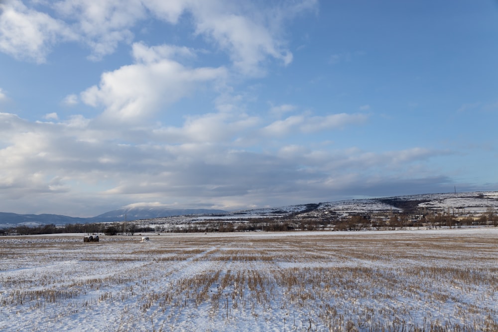 a large open field with snow on the ground