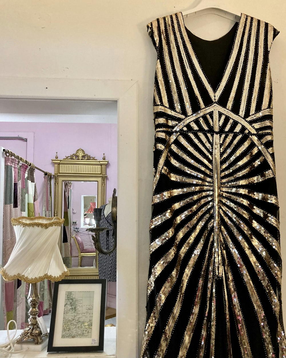 a black and gold dress hanging on a wall