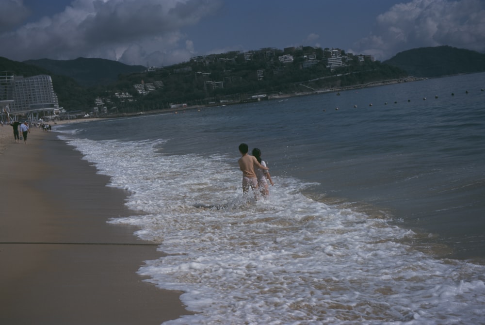 a couple of people that are standing in the water