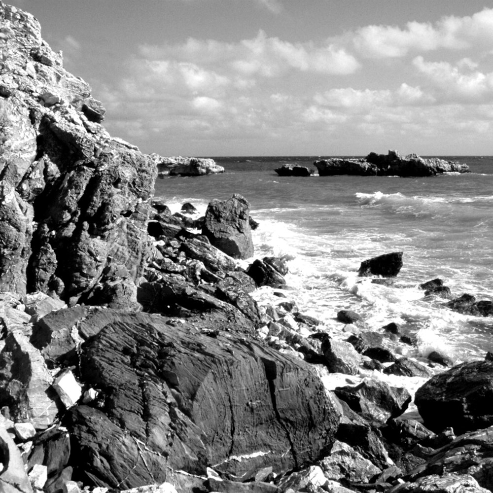 a black and white photo of a rocky beach