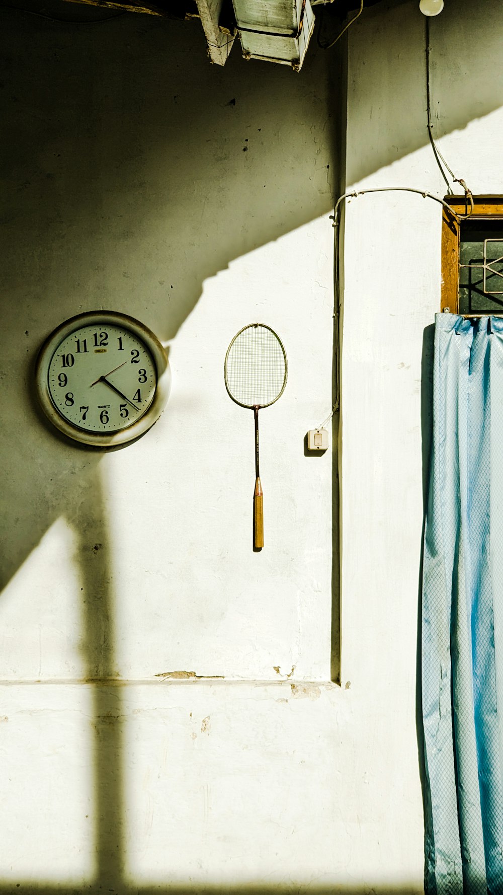 a tennis racket and a clock on a wall