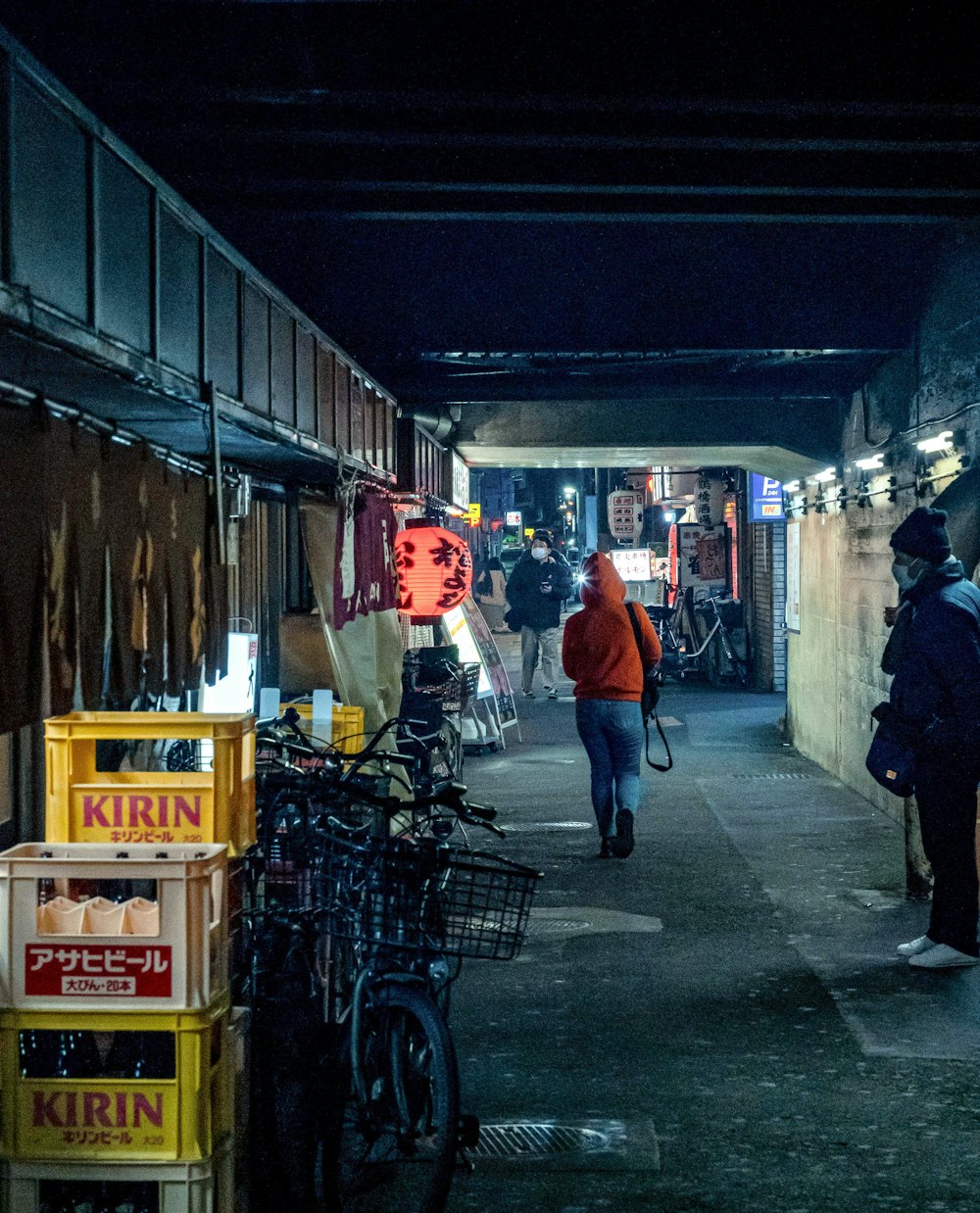 a group of people walking down a sidewalk next to a building