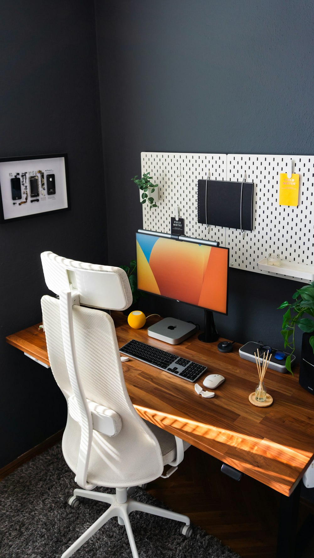 a desk with a computer, keyboard, mouse and plant