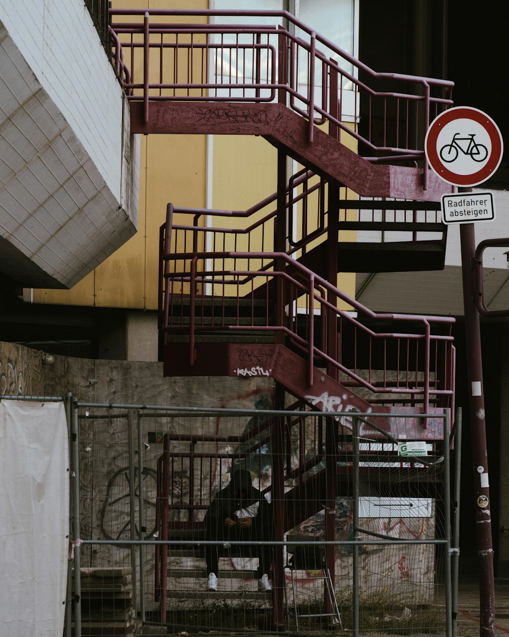 a red metal staircase next to a building