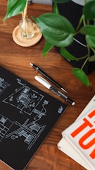 Designer sketchbook with hand-drawn interior concepts and color palettes on a wooden desk.