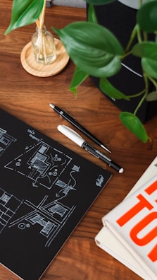 Creative architectural sketches spread on a wooden desk.