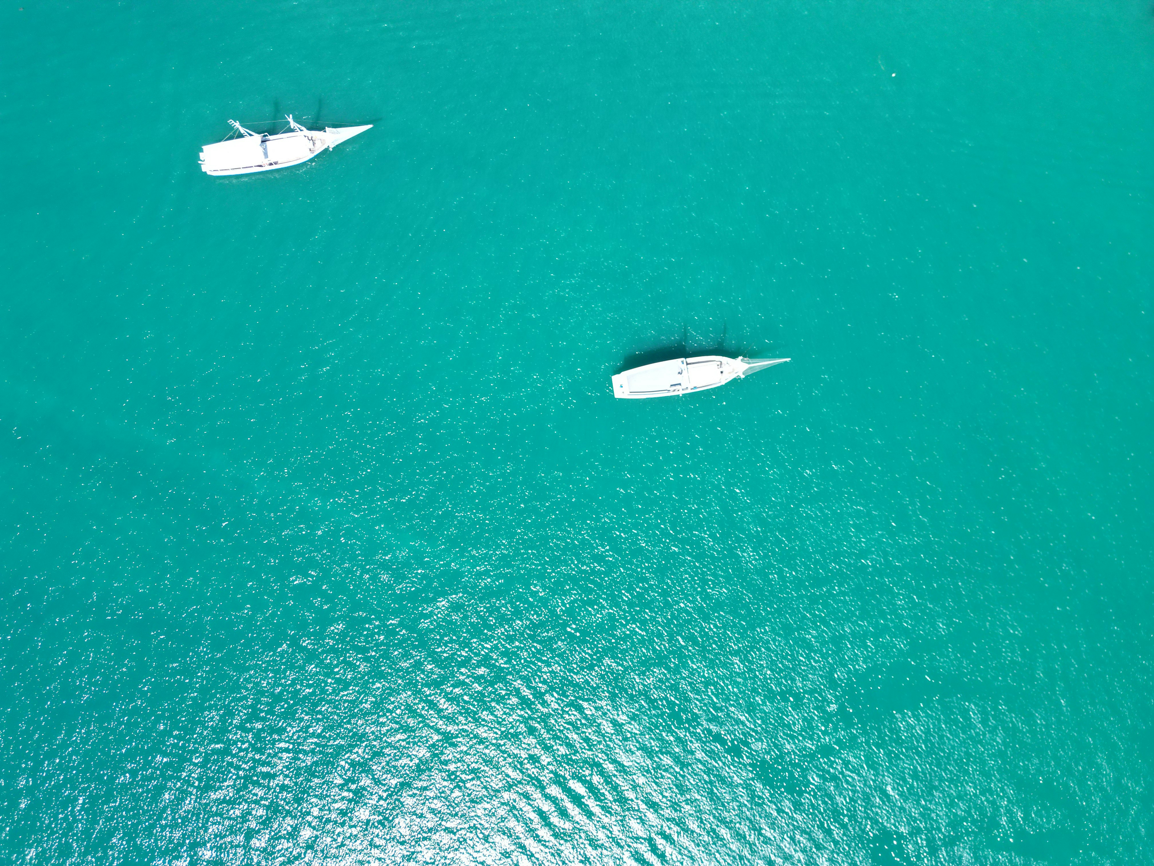 a couple of boats floating on top of a large body of water