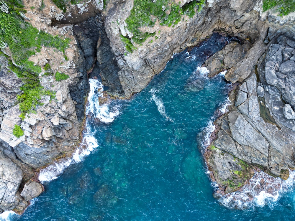 an aerial view of a body of water surrounded by rocks