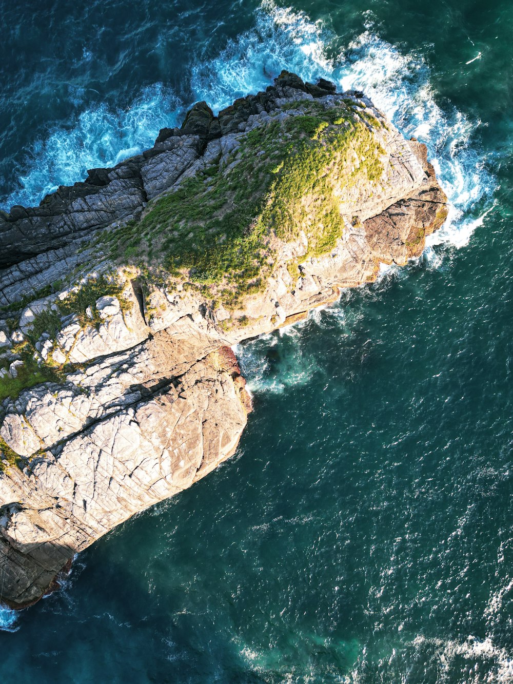 an aerial view of the ocean and rocks