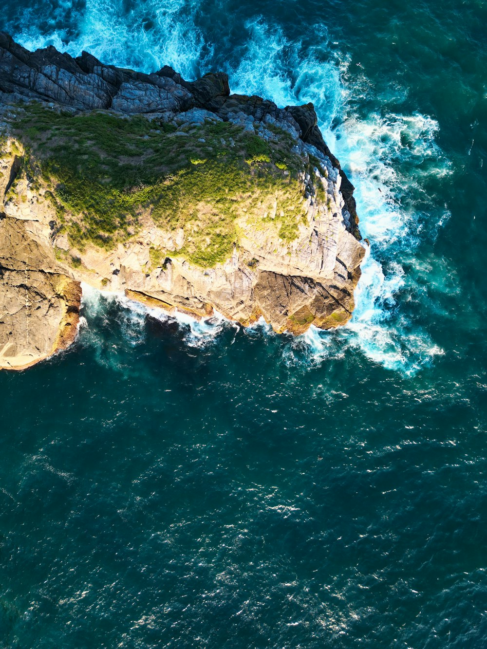 an aerial view of a rock formation in the ocean