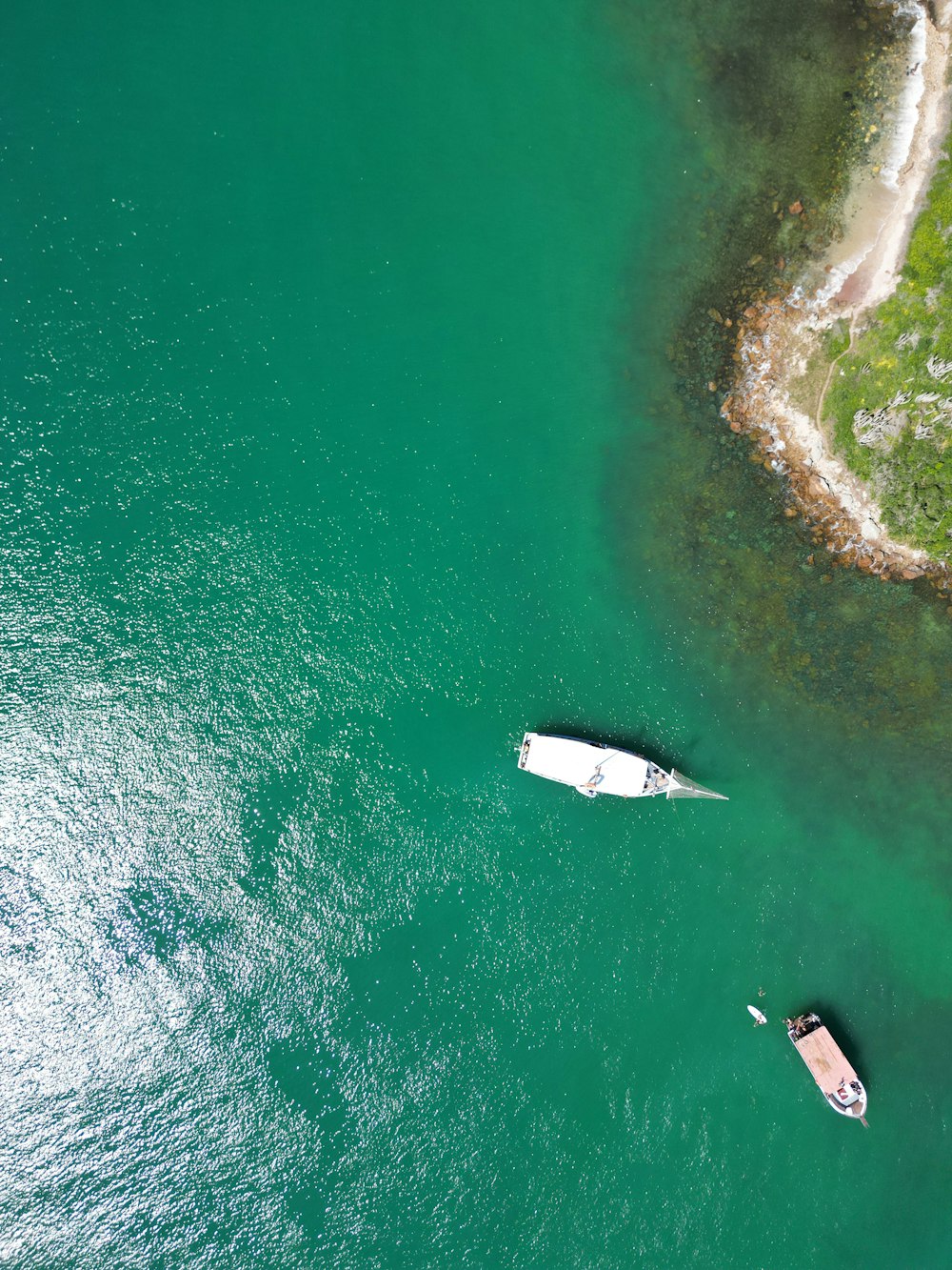 a couple of boats floating on top of a body of water