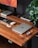 A close-up of a laptop and accessories on a wooden desk, showcasing a modern workspace.