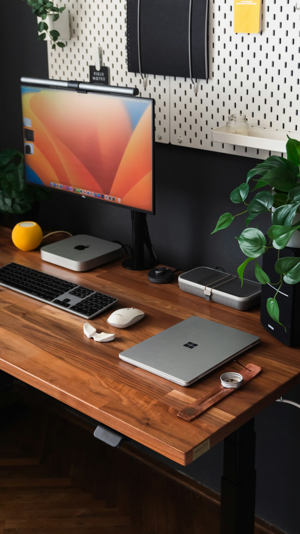 a desk with a laptop, keyboard, mouse and monitor on it