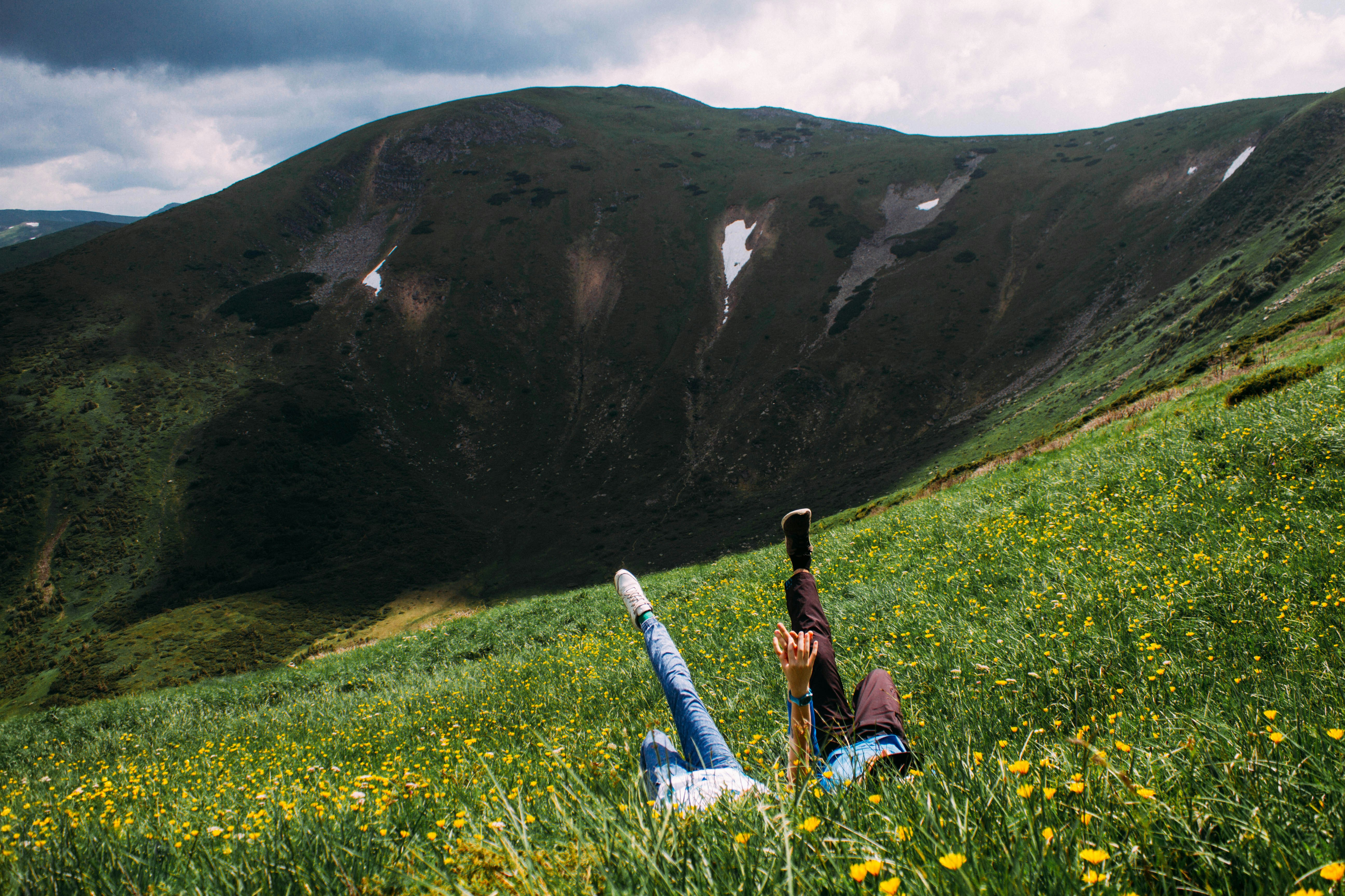 Eine Person, die auf einem Feld liegt, mit einem Berg im Hintergrund