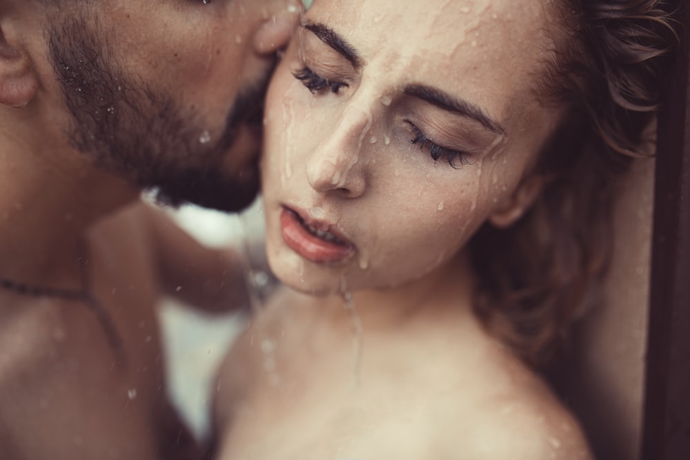 a man and a woman are kissing in the shower