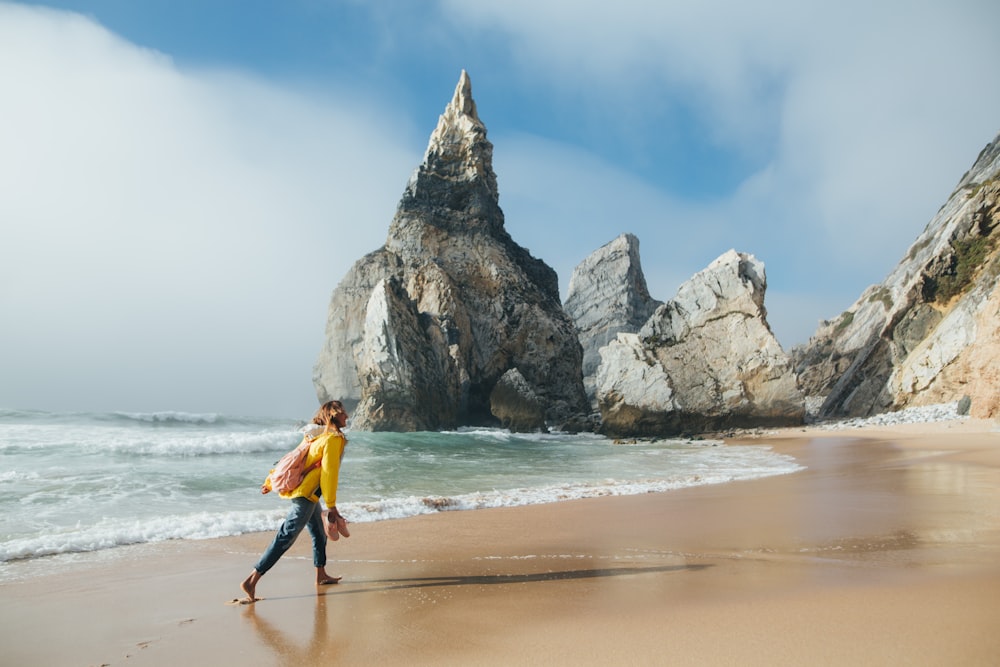 Un hombre caminando por una playa junto al océano