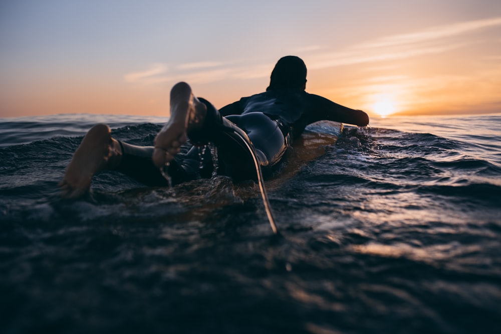 a person laying on a surfboard in the water