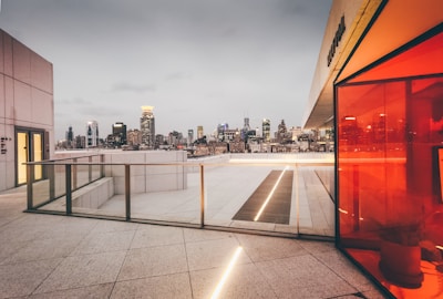 View of a rooftop terrace with city skyline in the background.