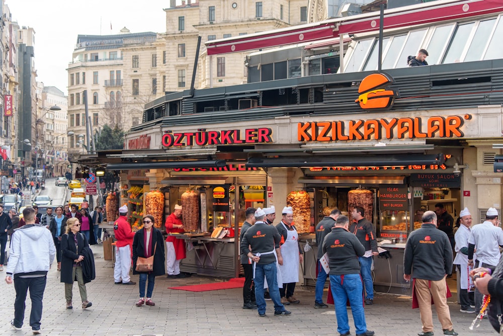 a group of people standing outside of a kiosk