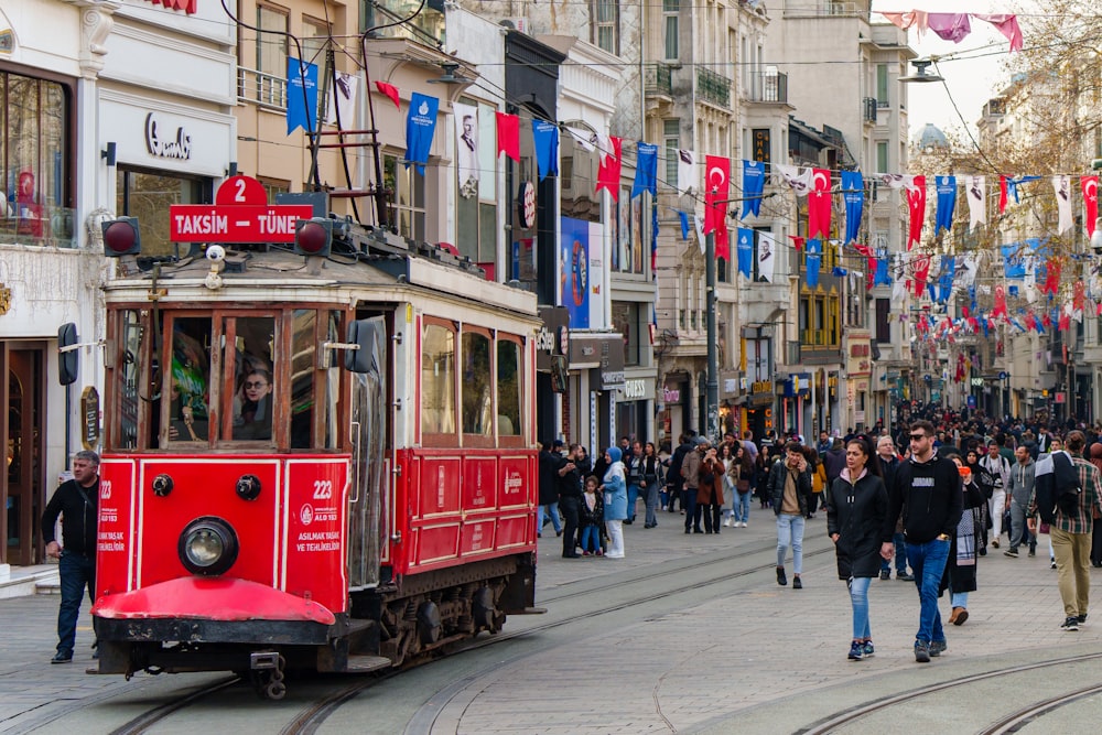 a group of people walking down a street next to a trolley