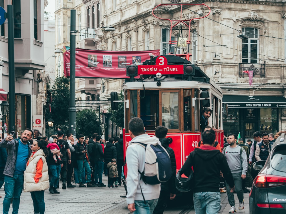 a group of people walking down a street next to a trolley